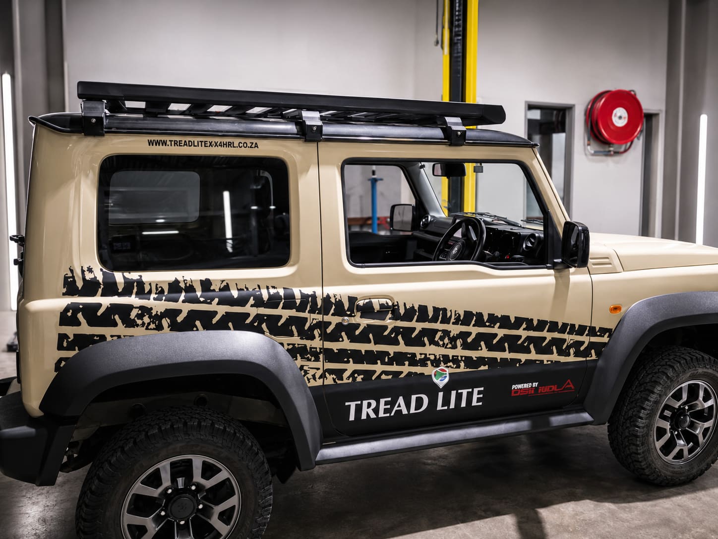 Tan 4x4 with a Tread Lite branded tyre-tread vehicle wrap